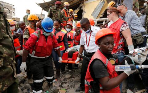 Kenya Red Cross rescuers evacuate a woman from the rubble of a six-storey building that collapsed last Friday after days of heavy rain, in Nairobi, Kenya, May 5, 2016. PHOTO BY REUTERS/Thomas Mukoya