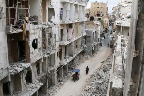Residents walk near damaged buildings in the rebel held area of Old Aleppo, Syria, May 5, 2016. PHOTO BY REUTERS/Abdalrhman Ismail