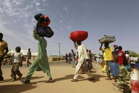 Men, with belongings, proceed towards a bus loading point during an evacuation of Nigerian returnees from Niger, at a camp for displaced people in Geidam, Yobe state, Nigeria, May 6, 2015. PHOTO BY REUTERS/Afolabi Sotunde