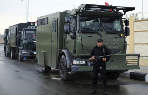 A riot police officer stands guard outside a police academy, where the trial of ousted Egyptian President Mohamed Mursi and members of the Muslim Brotherhood is due to take place, on the outskirts of Cairo