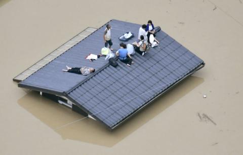 An aerial view shows local residents seen on the roof of submerged house at a flooded area as they wait for a rescue in Kurashiki, southern Japan, in this photo taken by Kyodo July 7, 2018. PHOTO BY REUTERS