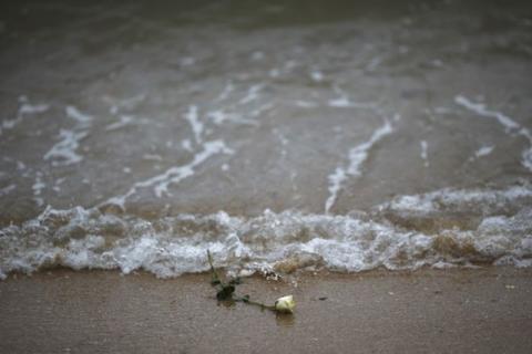 A rose is on the beach after being released by Thai children near a wave-shaped tsunami monument for victims of the 2004 tsunami in Ban Nam Khem, a southern fishing village destroyed by the wave, December 26, 2014. PHOTO BY REUTERS/Athit Perawongmetha