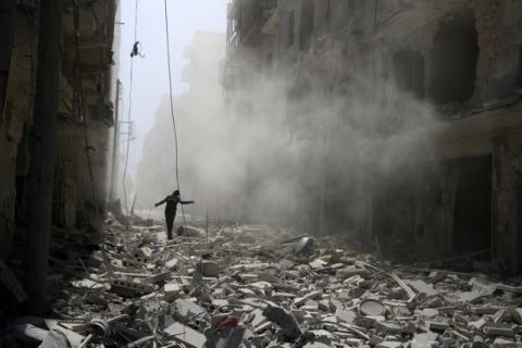 A man walks on the rubble of damaged buildings after an airstrike on the rebel held al-Qaterji neighbourhood of Aleppo, Syria, September 25, 2016. PHOTO BY REUTERS/Abdalrhman Ismail