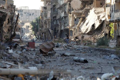 A view of people at a damaged street in Deir al-Zor, August 30, 2013. PHOTO BY REUTERS/Khalil Ashawi