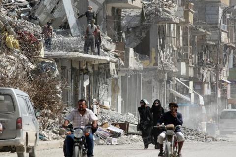 Women walk past rubble of damaged buildings in Raqqa, Syria, May 14, 2018. PHOTO BY REUTERS/Aboud Hamam