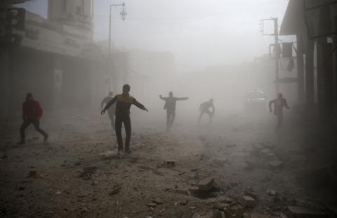 Civil defence members and civilians are seen running after an air raid in the besieged town of Douma in eastern Ghouta in Damascus, Syria, February 6, 2018. PHOTO BY REUTERS/Bassam Khabieh