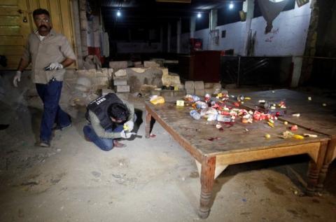 Security officials look for evidence at the site of a gun attack that killed four policemen in Karachi, Pakistan, June 23, 2017. PHOTO BY REUTERS/Akhtar Soomro