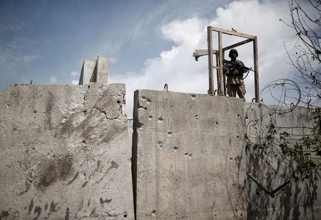 A member of the Afghan security force stands on top of a concrete barrier a day after attacks outside the Afghan parliament in Kabul, June 23, 2015. PHOTO BY REUTERS/Ahmad Masood
