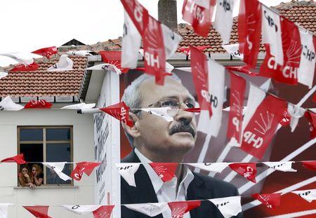 Women standing at a window listen to pro-Kurdish Peoples' Democratic Party (HDP) co-chair Selahattin Demirtas, as a poster of main opposition Republican People's Party (CHP) leader Kemal Kilicdaroglu is seen in the foreground, during an election rally for Turkey's June 7 parliamentary election, in Istanbul, Turkey, June 6, 2015. PHOTO BY REUTERS/Murad Sezer