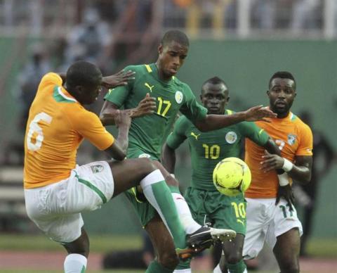 Senegal's Ricardo William Faty (2nd L) fights for the ball with with Ivory Coast's Yaya Toure (L) 