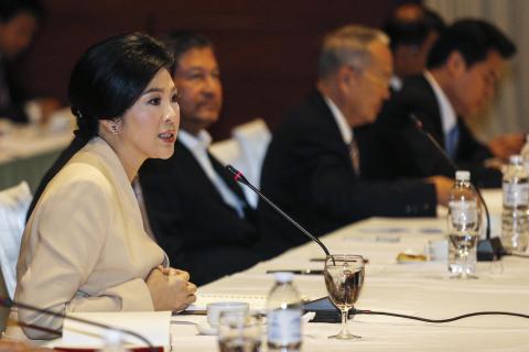 Thailand's Prime Minister Yingluck Shinawatra (L) speaks during a meeting with the Election Commission to discuss plans for a general election on February 2 at The Army Club in Bangkok