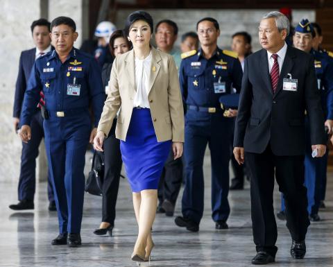 Thailand's Prime Minister Yingluck Shinawatra (C) leaves the Royal Thai Air Force headquarters after a cabinet meeting in Bangkok