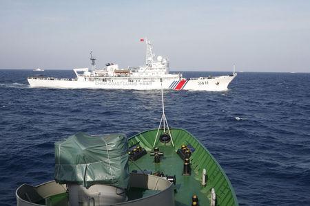 A ship (top) of Chinese Coast Guard is seen near a ship of Vietnam Marine Guard in the South China Sea, about 210 km (130 miles) off shore of Vietnam, May 14, 2014. PHOTO BY REUTERS/Nguyen Minh