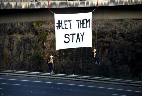 Protesters against the Nauru detention centre hang from a bridge above a freeway in Melbourne, Australia, February 11, 2016. PHOTO BY REUTERS/Tracey Nearmy