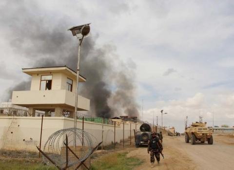 An Afghan security walks as smoke billows from a building after a Taliban attack in Gereshk district of Helmand province, Afghanistan, March 9, 2016. PHOTO BY REUTERS/Abdul Malik