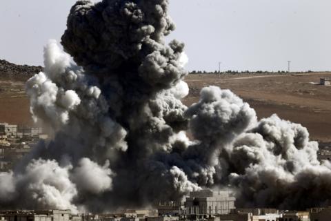 Smoke and dust rise over Syrian town of Kobani after an airstrike, as seen from the Mursitpinar crossing on the Turkish-Syrian border in the southeastern town of Suruc in Sanliurfa province October 22, 2014. PHOTO BY REUTERS/Kai Pfaffenbach