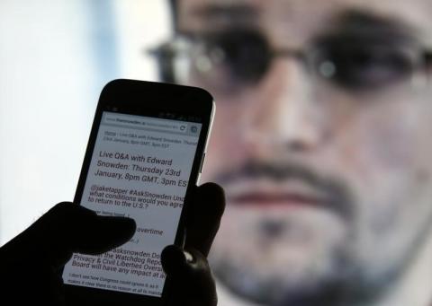 A man uses his cell phone to read updates about former U.S. spy agency contractor Edward Snowden answering users' questions on Twitter in this photo illustration, in Sarajevo