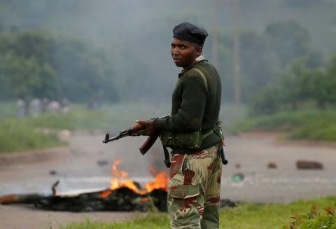 A soldier stands before a burning barricade during protests in Harare, Zimbabwe, January 15, 2019. PHOTO BY REUTERS/Philimon Bulawayo