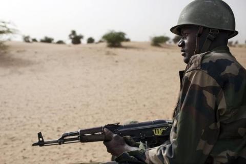 A Malian soldier, holding an AK-47 rifle, rides in a pick-up truck during a military escort outside Timbuktu, Mali, July 27, 2013. PHOTO BY REUTERS/Joe Penney