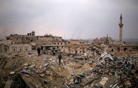 A member of forces loyal to Syria's President Bashar al-Assad stands with a civilian on the rubble of the Carlton Hotel, in the government controlled area of Aleppo, Syria. PHOTO BY REUTERS/Omar Sanadiki