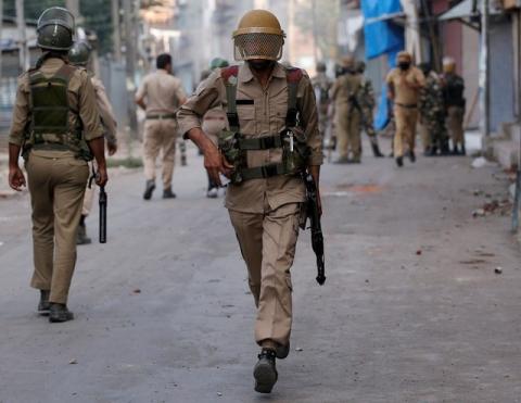 A policeman runs during a protest in Srinagar against the recent killings in Kashmir, July 18, 2016. PHOTO BY REUTERS/Danish Ismail