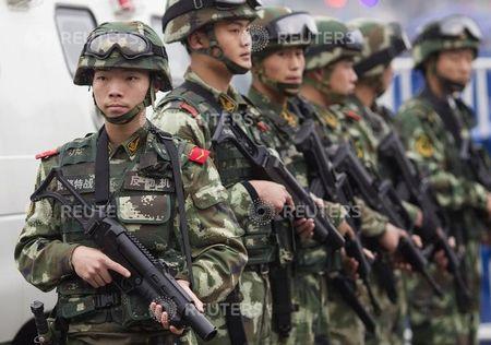 Armed paramilitary policemen stand guard in front of the Guangzhou Railway Station after a knife attack, in Guangzhou, Guangdong province, March 6, 2015. PHOTO BY REUTERS/Alex Lee