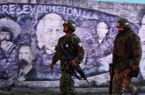 Soldiers stand guard next to at a crime scene, where men were killed inside a home by unknown assailants, in the municipality of San Nicolas de los Garza, Mexico, January 27, 2018. Picture taken January 27, 2018. PHOTO BY REUTERS/Jorge Lopez
