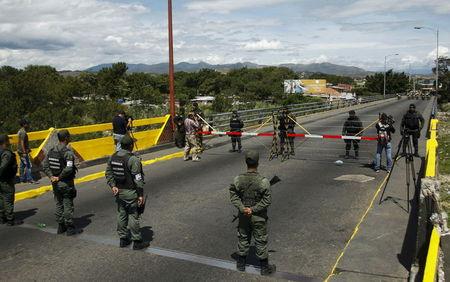 Venezuela's National Guards (bottom) stand in front of Colombia's soldiers at Simon Bolivar international bridge, on the border with Colombia, at San Antonio in Tachira state, Venezuela, August 20, 2015. PHOTO BY REUTERS/Carlos Eduardo Ramirez