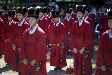 A university student dressed in traditional costume wipes sweat during the grand Confucian ceremony of Seokjeon at a shrine at Sungkyunkwan University in Seoul, South Korea, September 18, 2015. PHOTO BY REUTERS/Kim Hong-Ji