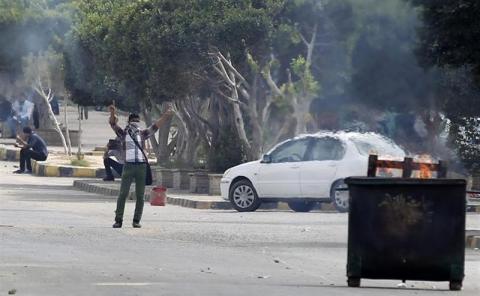 Al-Azhar University students who support the Muslim Brotherhood and deposed President Mohamed Mursi, shout slogans in front of riot police, during clashes at the university's in Cairo's Nasr City district