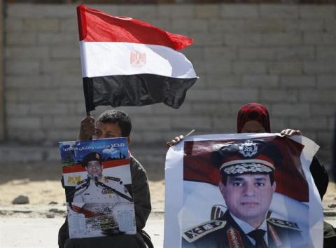 Supporters of Egypt's army chief Field Marshal Abdel Fattah al-Sisi sit outside a police academy, where the trial of ousted Egyptian President Mohamed Mursi and members of the Muslim Brotherhood is due to take place