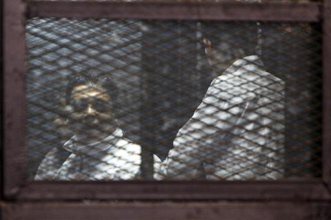 Muslim Brotherhood supporters convicted of playing a role in the killings of 16 policemen in August 2013 during the upheaval that followed the army's ouster of Islamist president Mohamed Mursi, stand behind bars during their trial in Cairo, February 2, 2015. PHOTO BY REUTERS/Mohamed Abd El Ghany