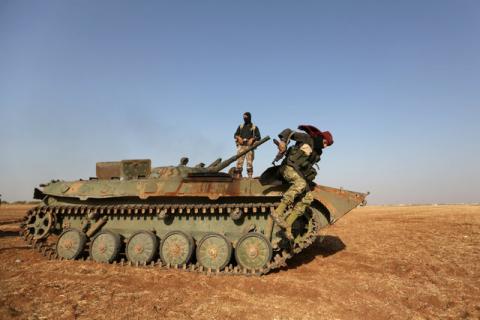 A rebel fighter jumps from a military vehicle on the outskirts of Syria Democratic Forces (SDF) controlled Tell Rifaat town, northern Aleppo province, Syria, October 22, 2016. PHOTO BY REUTERS/Khalil Ashawi