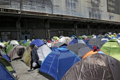 A refugee walks among tents at a makeshift camp for refugees and migrants at the port of Piraeus, Greece, March 30, 2016. PHOTO BY REUTERS/Alkis Konstantinidis