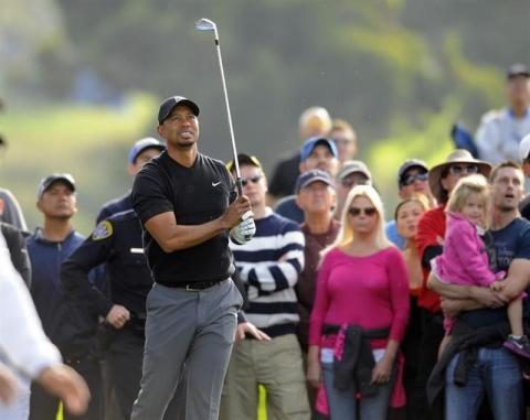 Tiger Woods watches after hitting his ball out of the rough on the twelfth hole during the third round of the Farmers Insurance Open golf tournament at Torrey Pines Municipal Golf Course