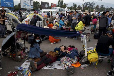 Tourists wait for their flights outside Nepal's Tribhuvan International Airport a day after a 7.9 magnitude earthquake, in Kathmandu, Nepal, April 26, 2015. PHOTO BY REUTERS/Athit Perawongmetha