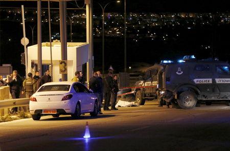 Israeli troops stand next to the covered body of a Palestinian whom they shot dead near the A-Zayyim checkpoint on the outskirts of East Jerusalem in the occupied West Bank, April 25, 2015. PHOTO BY REUTERS/Ammar Awad