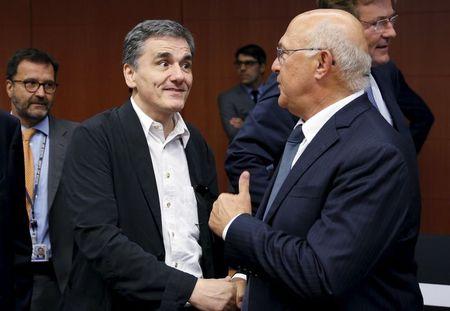 Greek Finance Minister Euclid Tsakalotos listens his French counterpart Michel Sapin (R) during a euro zone finance ministers meeting in Brussels, Belgium, August 14, 2015. PHOTO BY REUTERS/Francois Lenoir