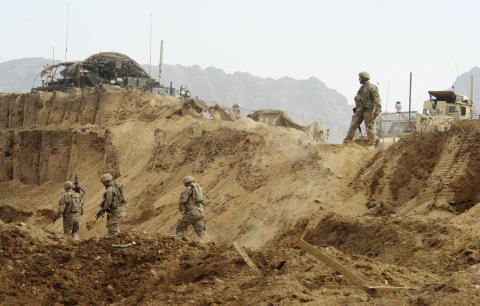 U.S. troops investigate the site of a suicide attack on a NATO base in Zhari, west of Kandahar province