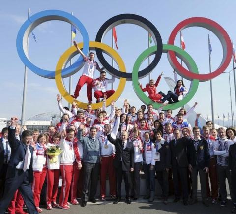 Russian President Vladimir Putin (C) and Russian Olympic medal winning athletes pose for a picture in Sochi, February 24, 2014. PHOTO BY REUTERS/Mikhail Klimentyev