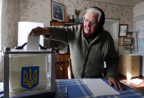 A local resident places her ballot into a mobile ballot box during a parliamentary election, at her home in Horodyshche near Chernihiv, October 26, 2014.PHOTO BY REUTERS/Stringer