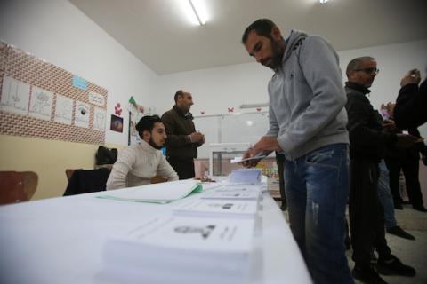A voter receives ballots at a polling station during the presidential election in Algiers, Algeria, December 12, 2019. PHOTO BY REUTERS/Ramzi Boudina