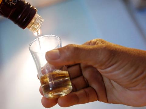 An employee pours whisky in a glass at a restaurant in Phnom Penh, Cambodia, October 18, 2018. PHOTO BY REUTERS/Samrang Pring