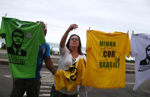 A woman takes a t-shirt with the image of Brazil's new president-elect, Jair Bolsonaro, in front of Bolsonaro's condominium at Barra da Tijuca neighborhood in Rio de Janeiro, Brazil, October 29, 2018. PHOTO BY REUTERS/Pilar Olivares