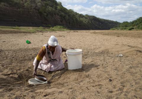 A woman gets water from a well dug in the Black Imfolozi River bed, which is dry due to drought, near Ulundi, northeast of Durban, January 20, 2016. PHOTO BY REUTERS/Rogan Ward