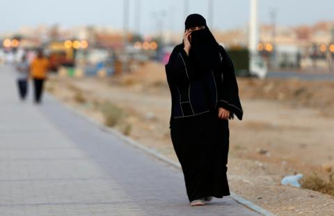 A Saudi woman speaks on a phone as she walks on a sidewalk in Riyadh, Saudi Arabia, September 21, 2017. PHOTO BY REUTERS/Faisal Al Nasser