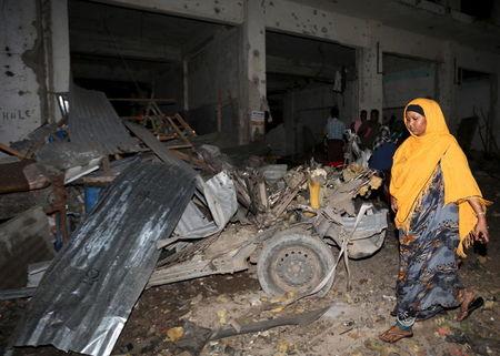 A Somali woman walks past the scene of a suicide car bomb attack near Juba hotel in capital Mogadishu, August 22, 2015. PHOTO BY REUTERS/Feisal Omar