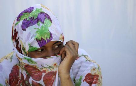 A migrant woman from Somalia covers her face with a scarf at a transit camp in Gevgelija, Macedonia, after entering the country by crossing the border with Greece, September 12, 2015. PHOTO BY REUTERS/Ognen Teofilovski