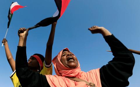 A Sudanese woman chants slogans and waves national flag in celebration following Sudan's ruling military council and a coalition of opposition and protest groups reached an agreement to share power during a transition period leading to elections, along the streets of Khartoum, Sudan, July 5, 2019. PHOTO BY REUTERS/Mohamed Nureldin Abdallah