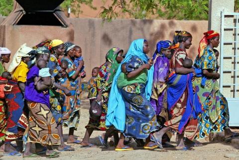 Rural women who have carried their malnourished children for days across the Sahel desert in search of [food] rush into an emergency feeding center in the town of Guidan Roumdji, southern Niger, July 1, 2005. PHOTO BY REUTERS